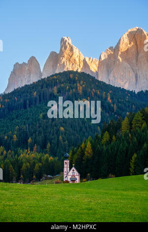 Schöne Herbst Wald mit barocken Kirche St. Johann in Val di Funes, Dolomiten, Italien Stockfoto