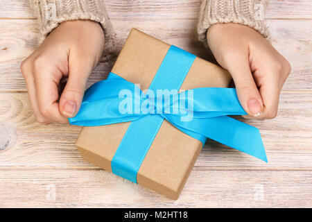 Girl Band eine einfache blaue Schleife auf einer Geschenkbox. Im Klartext Handwerk Papier und blaue Band umwickelt. Den letzten Schliff. Stockfoto