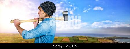 Mann mit Axt vor grüne Landschaft Stockfoto