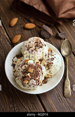 Sommer Nachtisch. Kugeln Schoko Vanille Eis mit Muttern in die Schüssel. Stockfoto