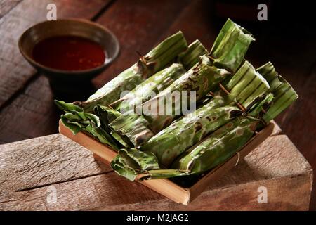 Otak-otak Palembang, den gegrillten Fisch Kuchen im Bananenblatt Parzellen, Serviert mit scharfer Essig Sauce Stockfoto