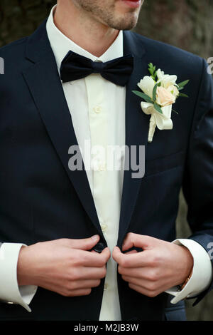 Stellen Bräutigam mit Knopfloch. Hochzeit Details, schöne Ansteckblume Stockfoto