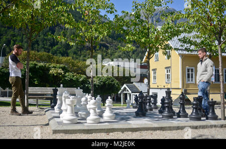 Zwei Freunde Schach spielen auf einem riesigen Schachbrett, Odda, Norwegen Stockfoto