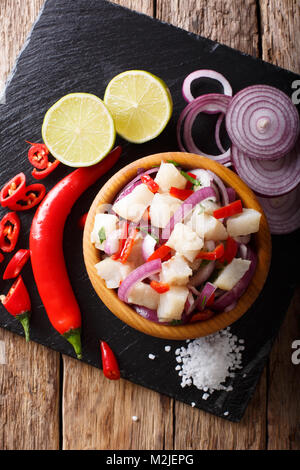 Frisch zubereitete Ceviche aus weißen Fisch mit Zwiebeln und Paprika close-up in einer Schüssel auf den Tisch. Vertikal oben Ansicht von oben Stockfoto