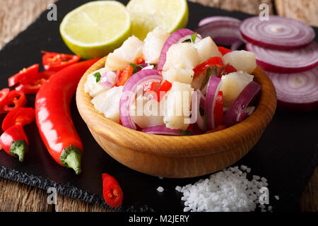 Frisch zubereitete Ceviche aus weißen Fisch mit Zwiebeln und Paprika close-up in einer Schüssel auf dem Tisch. Horizontale Stockfoto