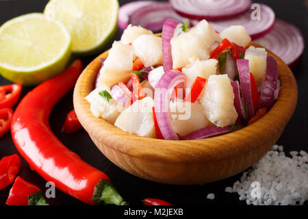 Gesunde Fische ceviche von Kabeljau mit Zwiebel und Pfeffer close-up auf einem Teller auf den Tisch. Horizontale Stockfoto
