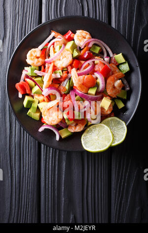 Lecker ceviche von Garnelen mit Gemüse, Gewürze und Kalk in der Nähe auf einem Teller auf den Tisch. Vertikal oben Ansicht von oben Stockfoto