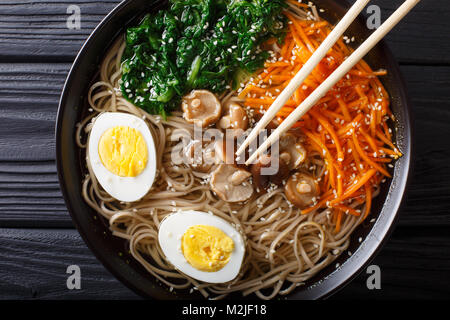 Soba Nudeln Suppe mit Gemüse, Shiitake-Pilze, Ei und Sesam close-up in eine Schüssel geben. Horizontal oben Ansicht von oben Stockfoto