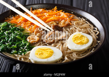 Soba Nudeln Suppe mit Gemüse, Shiitake-Pilze, Ei und Sesam close-up in eine Schüssel geben. Horizontale Stockfoto