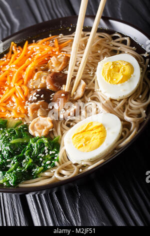 Buchweizen Suppe, Nudeln mit Gemüse, Shiitake-Pilze, Ei und Sesam close-up in eine Schüssel. Vertikale Stockfoto