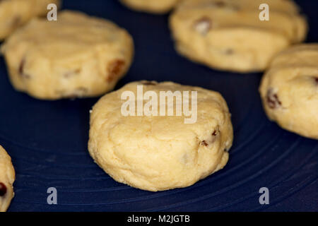 Hausgemachte Obst scones wie rock Kuchen auf einem Silikon backen Mat bereit in den Ofen bekannt. Stockfoto