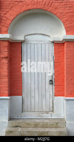 Geheime gesperrt weiße Holztür in Red brick wall Stockfoto