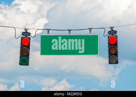 Horizontale Schuß von zwei roten Ampel von einem Kabel mit einem leeren Straße Anmelden - zwischen mit blauem Himmel und Wolken dahinter hängen. Stockfoto