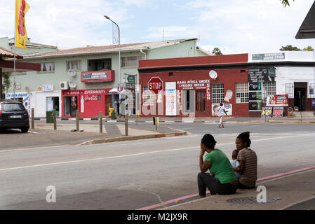 Stadtzentrum von Darling in der Western Cape Region Südafrikas. Lokale Frauen sitzen mit einem Kind, das am Straßenrand Stockfoto