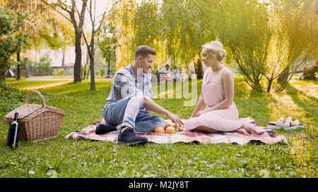 Junge liebende Paar lachen und Spaß haben, Ausgabe von Datum und Zeit in den öffentlichen Park Stockfoto