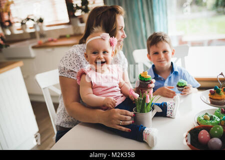 Glückliche Kinder mit Mutter essen Cupcakes Stockfoto