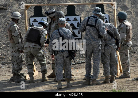 100418-A-6124 H-060 JOINT SECURITY STATION GERECHTIGKEIT, Irak: Soldaten mit der 22 Brigade, 6 irakische Armee Division Transition Team und IA Soldaten werfen Sie einen Blick auf Ziel Papiere der IA der Soldaten nach dem Feuern 16 Schuss Munition während einer live Feuer Bereich Übung hier, 26.04.19. (U.S. Armee Foto von Pfc. Kimberly Hackbarth, 4 SBCT PAO, 2. Inf. Div., USD-C), nachdem er 16 Runden, die von den 1st Armored Division und Fort Bliss Stockfoto