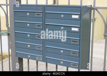 Neue metallische modernes graues Mailboxen hängen auf einem eisernen Gitter auf sity Straße Stockfoto