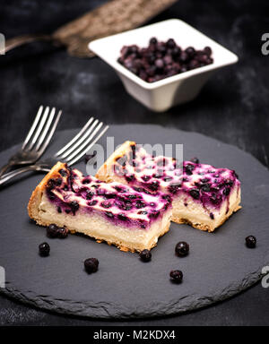 Pie von Hüttenkäse und Heidelbeeren auf schwarzem Hintergrund, Ansicht von oben Stockfoto