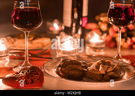 Romantisches Abendessen für Zwei mit Wein, Kerzen, Blumen Stockfoto