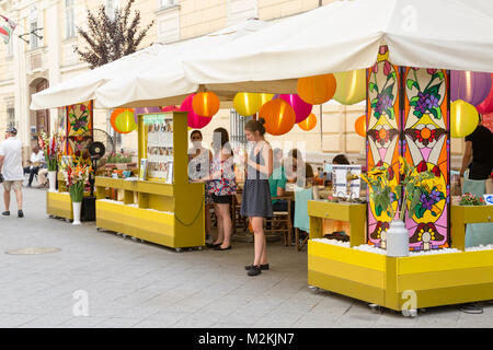 Junge Frau Eis essen am Eingang der Sidewalk Cafe in Budapest, Ungarn. Stockfoto