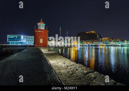 ALESUND, Norwegen - 05 Januar, 2018: Leuchtturm im Hafen von Alesund bei Nacht. Es ist eine Hafenstadt, und ist für seine Konzentration des Jugendstils arc festgestellt Stockfoto