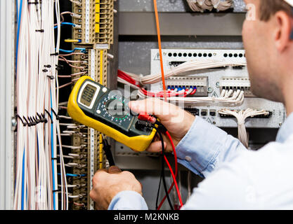 Ingenieur die Stromversorgung mit einem Multimeter prüfen. Null Wert der Spannung am Multimeter. Stockfoto