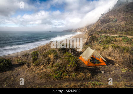 Schön orange Zelt aufgeschlagen auf einer Klippe mit Blick auf Strand und Meer in Point Reyes Stockfoto