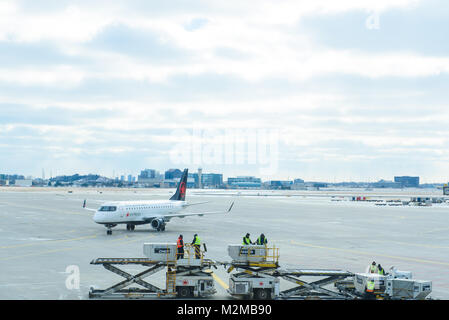 Toronto, Ontario/Kanada - Februar 5, 2018: Air Canada Jet auf Asphalt mit einigen Flughafen Arbeiter im Vordergrund geparkt am Internationalen Flughafen Pearson Stockfoto