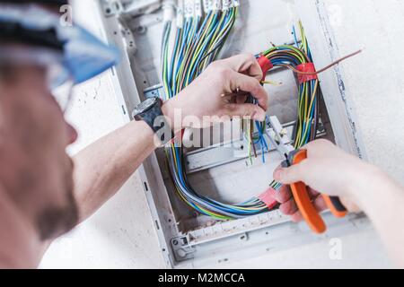 Elektrische Anlage Installation von Professionellen kaukasischen Elektriker. Bau- und Energiewirtschaft. Stockfoto