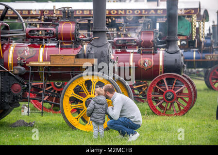 Vater zeigt seine neugierigen Sohn eine Dampfmaschine Schlepper, Masham, North Yorkshire, Großbritannien Stockfoto