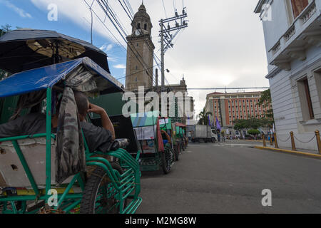 Eine Warteschlange von Pedal Taxi's bei ruhenden Fahrer seite des Manila Kathedrale in der Altstadt, Spanische Viertel, Manila, Philippinen, Stockfoto