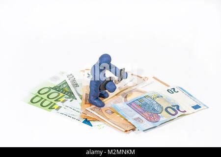 Abstrakte Bild der finanziellen Betrügereien. Kleine Figur aus dem Spiel Ton in Handschellen. Stockfoto