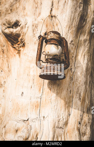Vintage petroleum Lampe aufhängen an Haken auf grunge Holzwand. Stockfoto