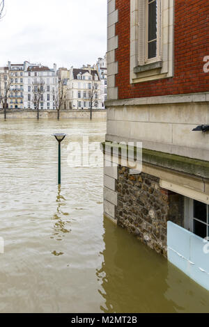 Ansicht einer brick House am Kai der Seine in Paris, halb durch das Wasser während der Flut Episode von Januar 2018 getaucht, mit historischen Gebäuden Stockfoto