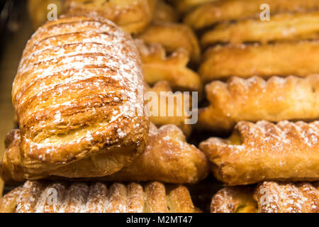Makro Nahaufnahme von viele normale Butter Croissants auf Anzeige in der Bäckerei mit Puderzucker auf Gebäck Stockfoto
