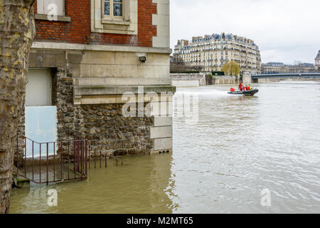 Paris, Frankreich, 29. Januar 2018: Taucher aus der Pariser Feuerwehr auf einem Motorboot Pass bei voller Geschwindigkeit vor einem Brick House Hälfte von der versunkenen Stockfoto