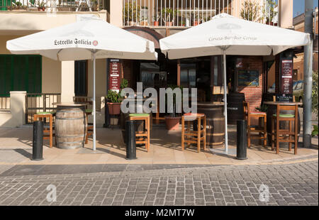 MALLORCA, SPANIEN - 24. JULI 2013: Sonnenschirme und Sitzgelegenheiten außerhalb des gemütlichen kleinen Restaurant "La Taberna" an einem sonnigen Tag am 24. Juli 2013 in Can Pastilla, Mallorca, Stockfoto