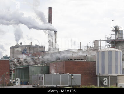BILLINGSFORS, DALSLAND, Schweden am 1. Juli 2012: Industrieschornsteinen mit Dämpfen und Rauch in Billingsfors Papierfabrik an einem bewölkten Tag am 1. Juli 2012 Stockfoto