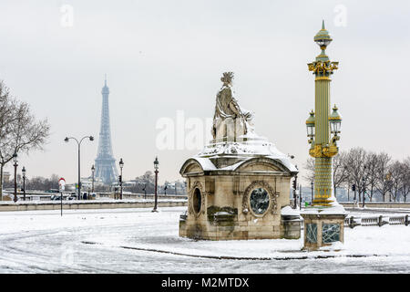 Winter in Paris im Schnee. Der von Schnee bedeckte Concorde-Platz mit der Statue von Marseille im Vordergrund und dem Eiffelturm in der Ferne. Stockfoto