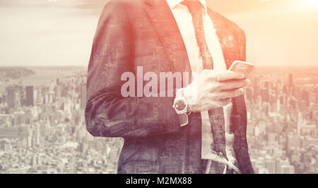 Doppelbelichtung Erfolg business Mann mit Smart Phone und Stadt im Hintergrund. Konzept Geschäftsmann Lebensstil Stockfoto