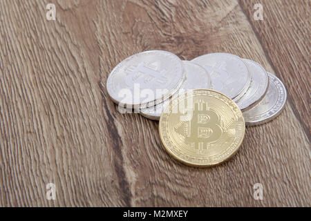 Silber bitcoins und ein Gold auf einem Holztisch Stockfoto