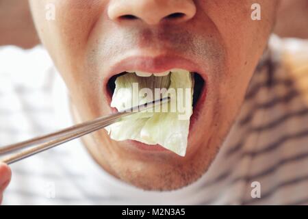 Closeup Asiatischen männlich Essen frische pflanzliche Nahrung, Napa Kohl, im chinesischen Stil mit Essstäbchen. Konzept und Idee des Gesunden. Stockfoto