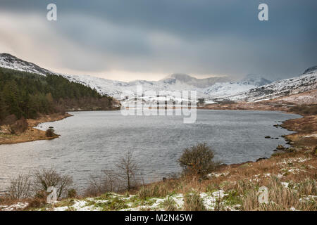 Schönen Sonnenaufgang Landschaft Bild im Winter von Llynnau Mymbyr in Snowdonia National Park mit Schnee bedeckte Berge im Hintergrund Stockfoto