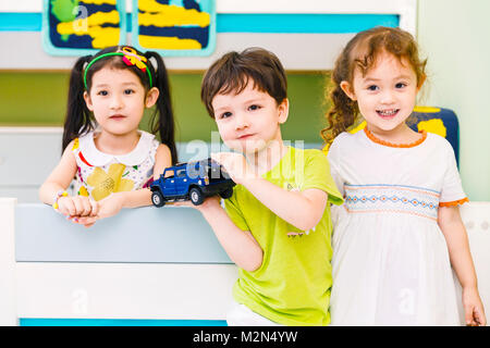 Glückliche Kinder spielen auf dem Bett Stockfoto