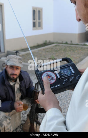 NANGARHAR, Afghanistan (18. Januar 2010) - 100118-A-3421S-218: SHINWAR Provinz, Afghanistan – auf der Suche nach einen neuen Radiosender Shinwar Bezirk einen jungen Afghanen, mit Hilfe der afghanischen Grenze Polizei Offizier, manipuliert das Zifferblatt von einer Handkurbel Radio von afghanischen nationalen und Koalition Sicherheitskräfte verteilt.  Radios und neue Radiosender sind Teil einer Medien-Informationen-Initiative gefördert durch die International Security Assistance Force [ISAF] Aufstandsbekämpfung Programm. Georgiens Armee Nationalgardisten des 1st Squadron, 108. Kavallerie-Regiment, Task Force Mountain Krieger haben o Stockfoto