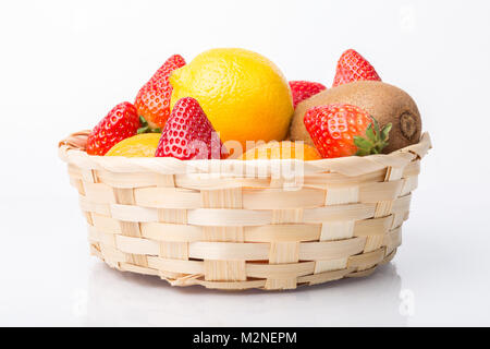 Sortierte Früchte im Weidenkorb isoliert auf weißem Stockfoto