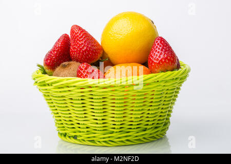 Sortierte Früchte im Weidenkorb isoliert auf weißem Stockfoto