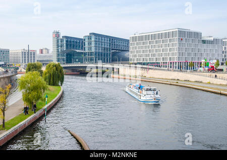 Berlin, Deutschland - 9. Oktober 2015: Touristische Boot auf der Spree mit Berlin Hauptbahnhof (Berlin Hauptbahnhof) Mit der Oberfläche aus Glas. Stockfoto