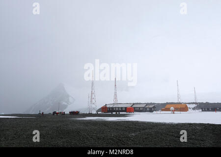 Panorama Eco Touristen besuchen entfernten Antarktis Station bei windigen Schneesturm horizontale hereinwehendem Schnee weißen Berg Hintergrund hoch radio Antennen Stockfoto